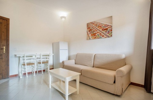 Costa Serena Apartment | A sophisticated space designed to accommodate up to four people, where comfort and style meet. The living room features a comfortable double sofa bed, while the bedroom, equipped with a double bed, offers an intimate and relaxing atmosphere. The modern b